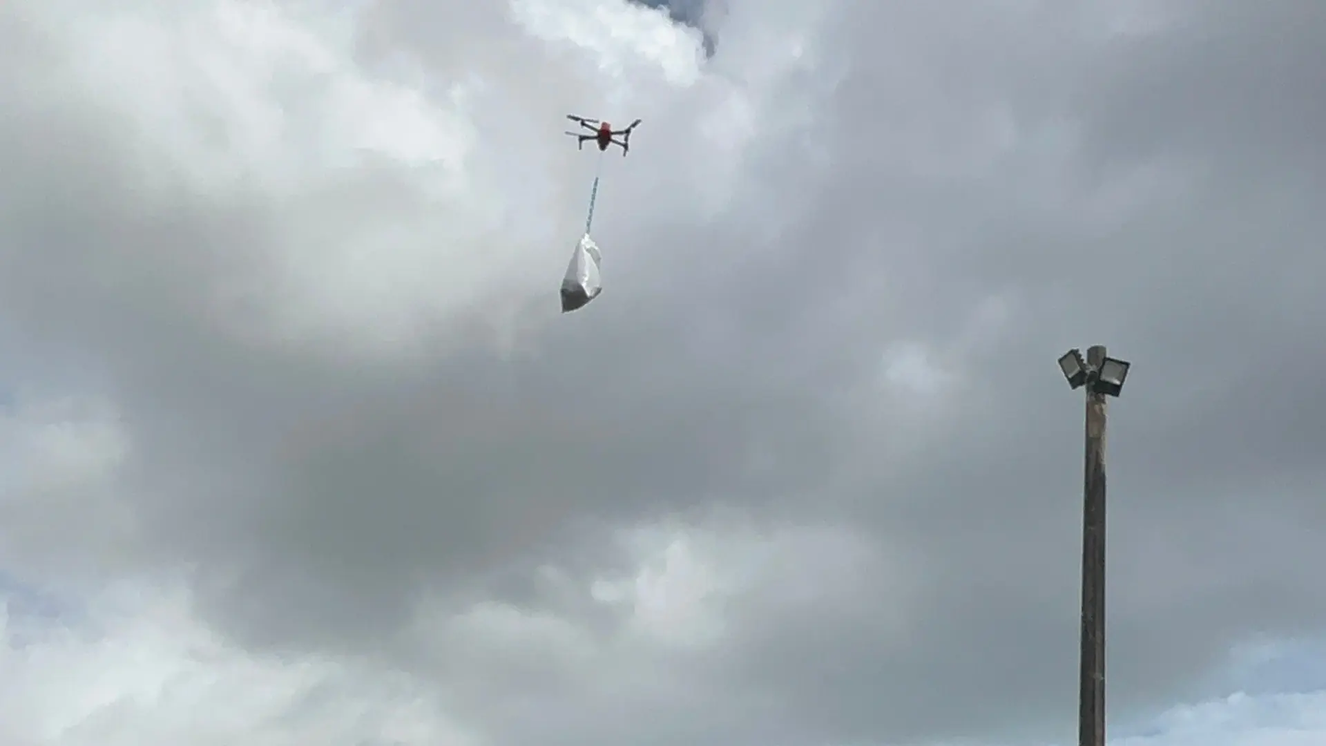 Drone carrying cargo flying over site - AirSight